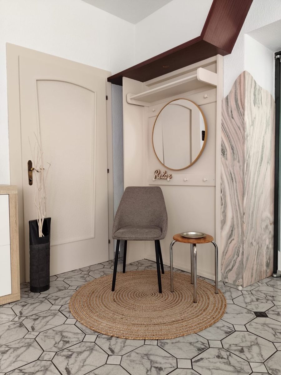 Empfangsbereich mit Sitzgelegenheit und Garderobe